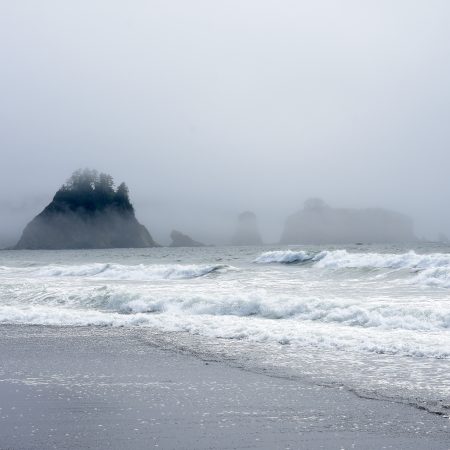 scenic view of the ocean with small islands jutting out of he water.