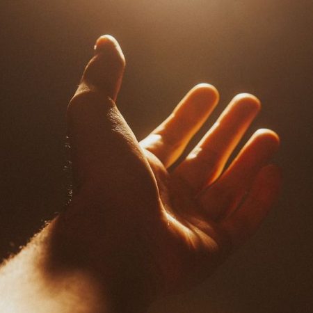 A man's hand reached out in mercy and prayer